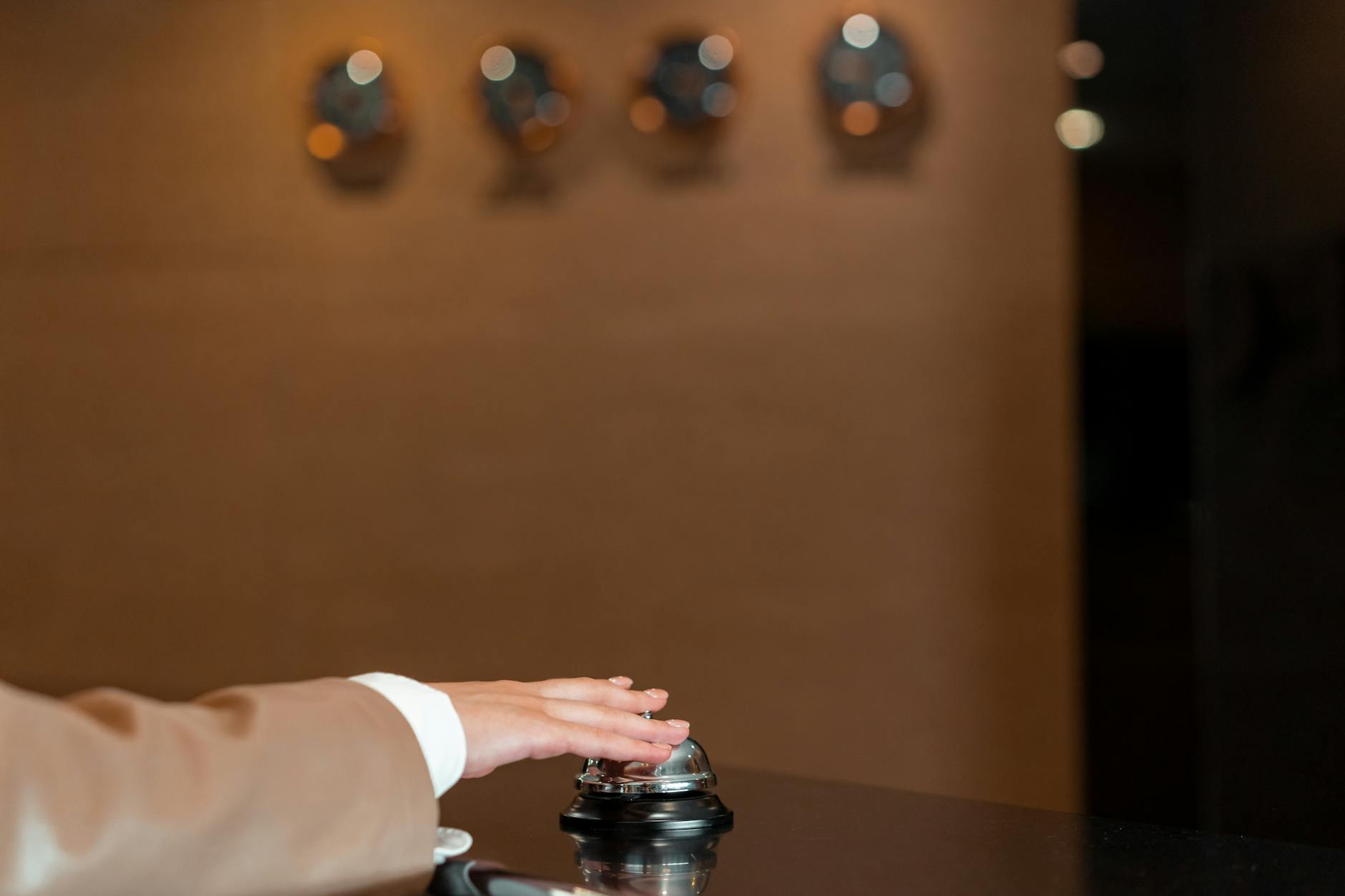 Professional hotel front desk area with staff member assisting guests during check-in process