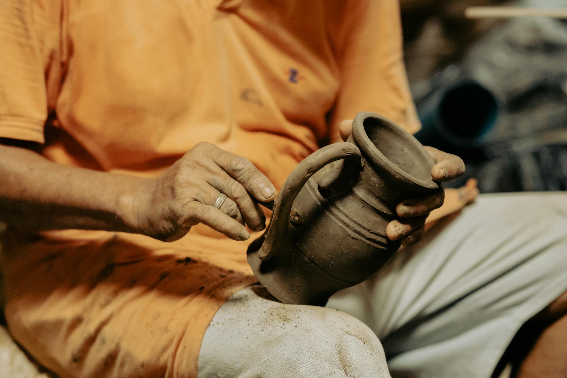 Hands working with clay on pottery wheel during skill-sharing workshop