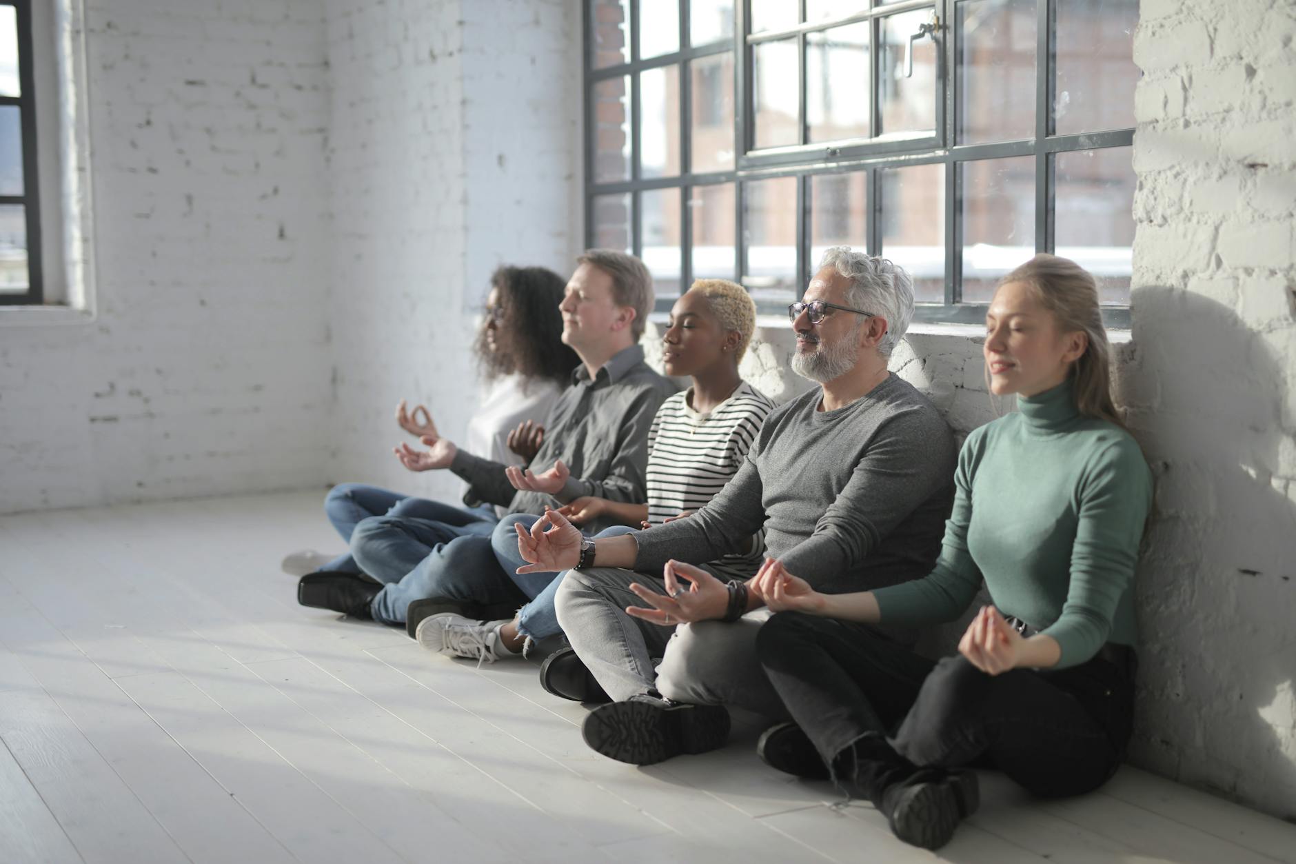 Professional person in business attire sitting peacefully outdoors in meditation pose
