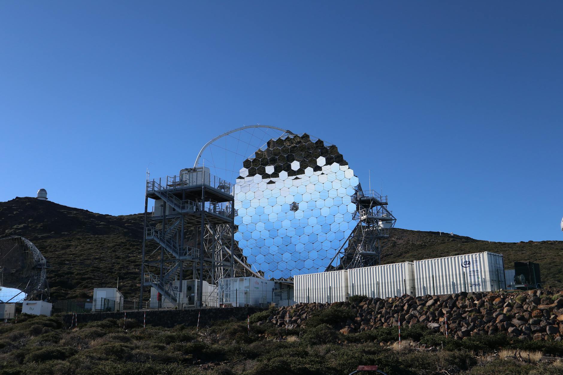 Large astronomical telescope dome under clear desert sky during golden hour