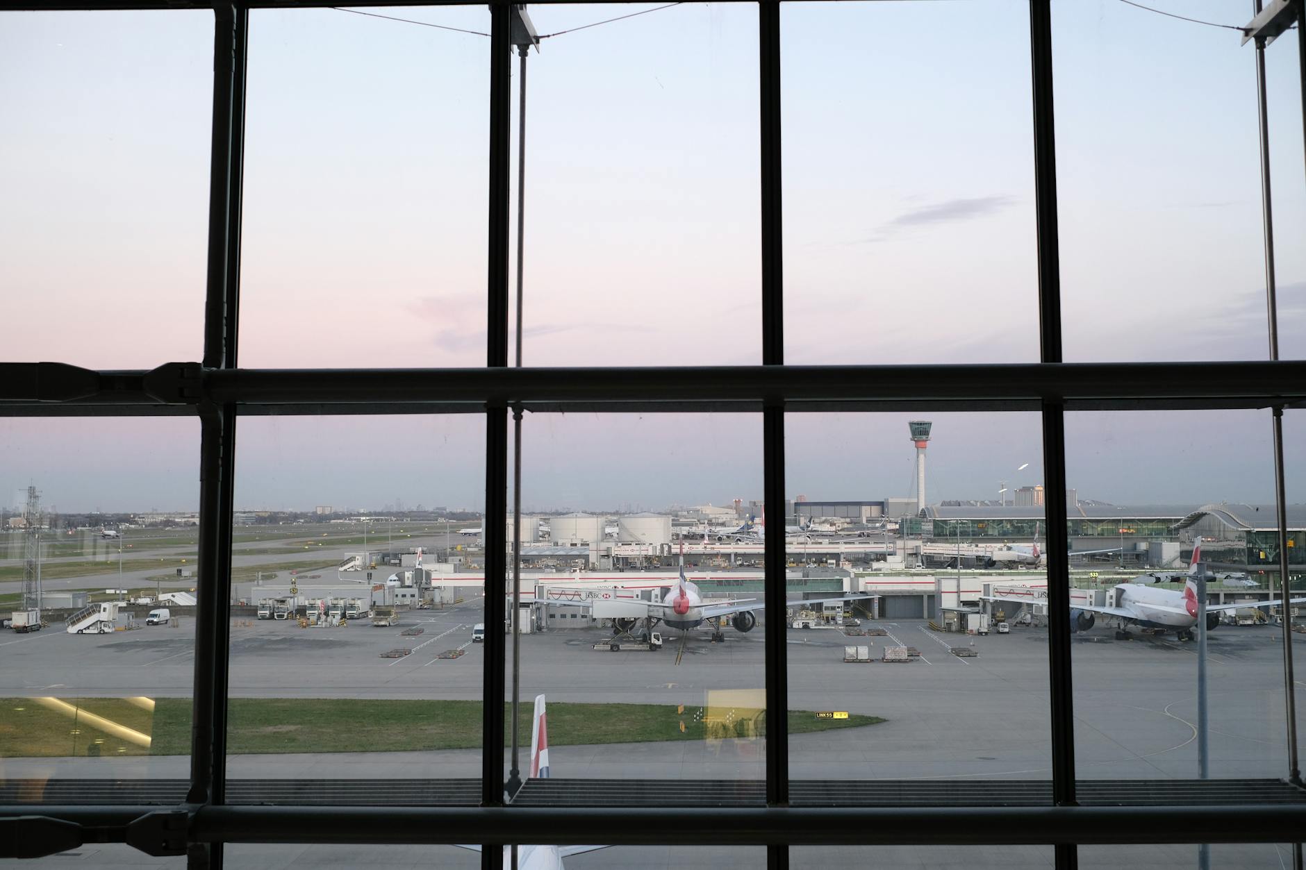 Busy airport terminal with departure gates and travelers walking with luggage