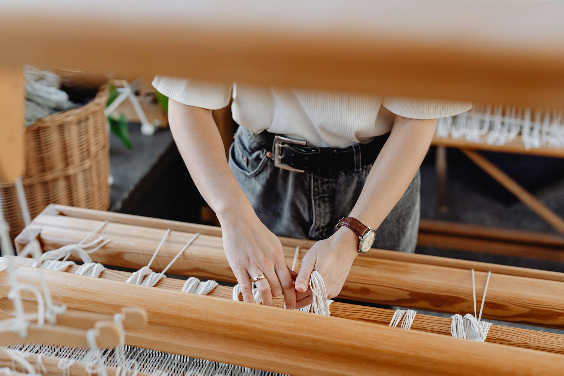 Close-up of hands working on colorful traditional textile with intricate geometric patterns
