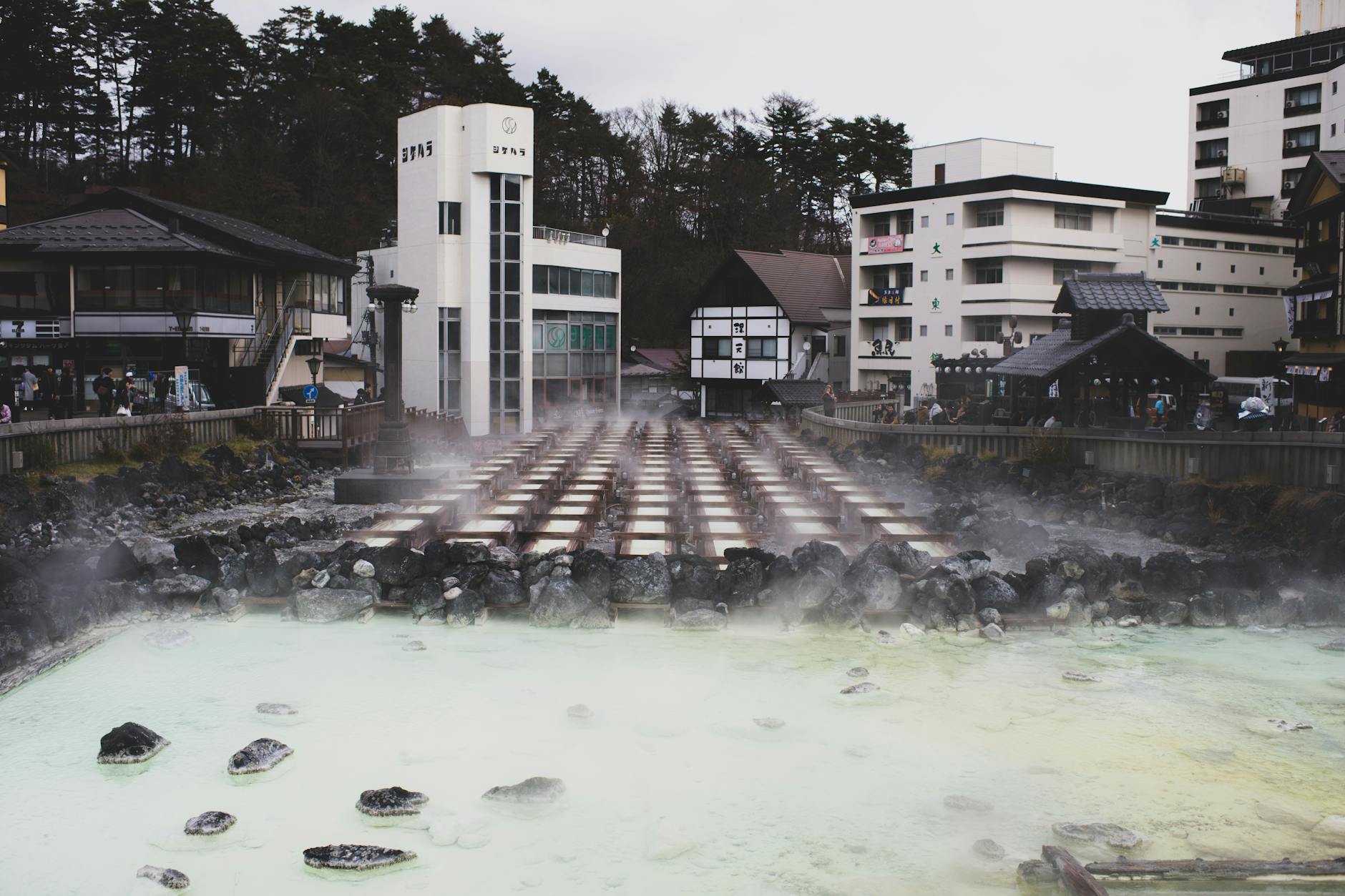 Traditional Japanese hot spring bath surrounded by snow and forest