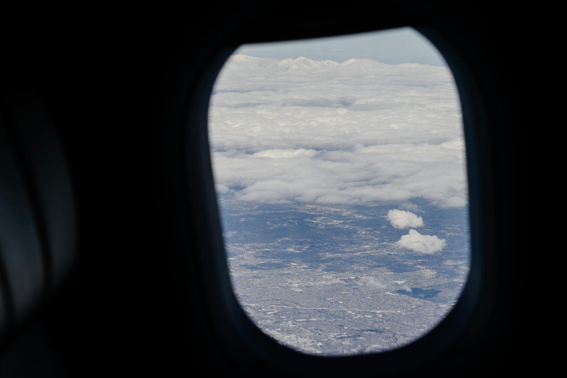 View from airplane window showing wing and sky during flight