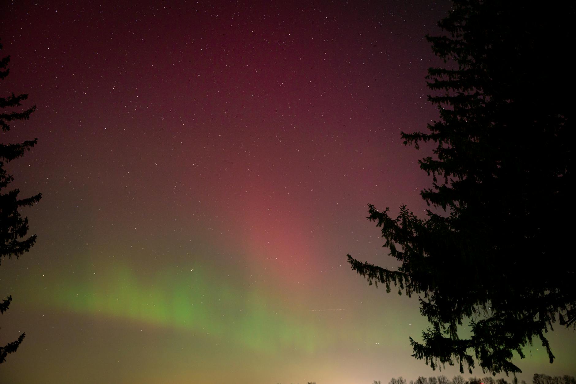 Northern lights dancing across the Arctic sky above snow-covered landscape