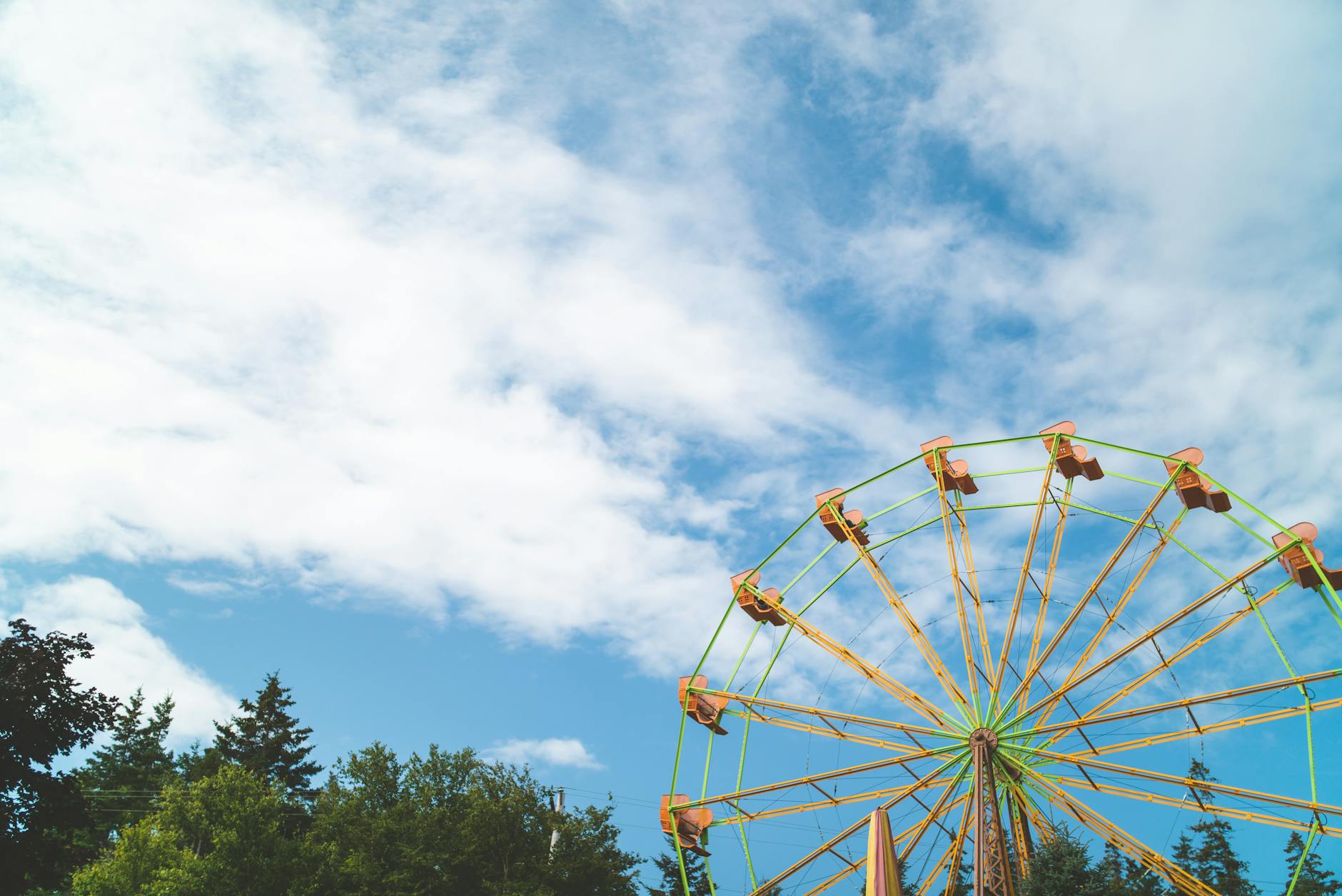 Abandoned ferris wheel with rust and weathering against gray sky