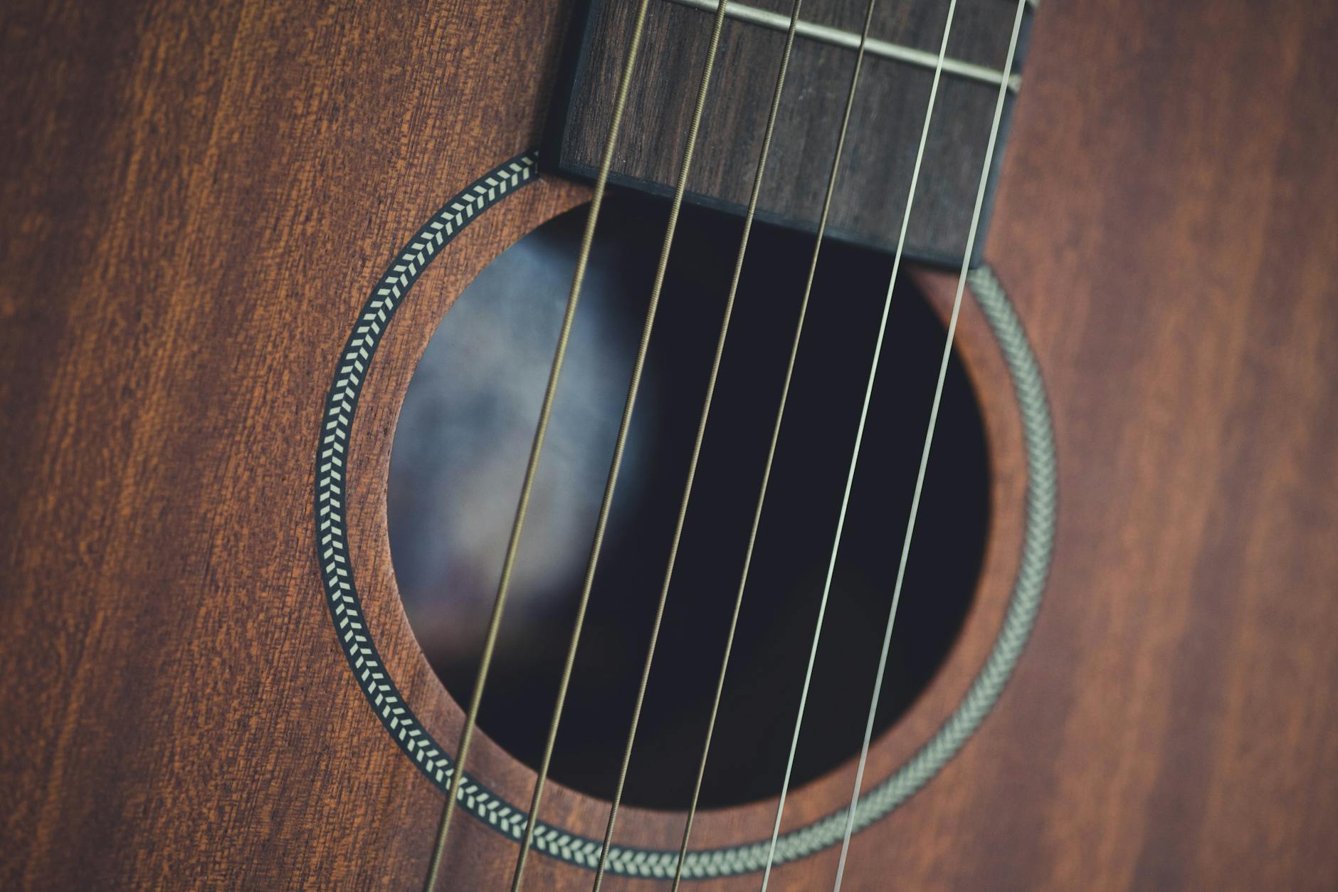 Close-up of acoustic guitar being played, showing analog musical practice