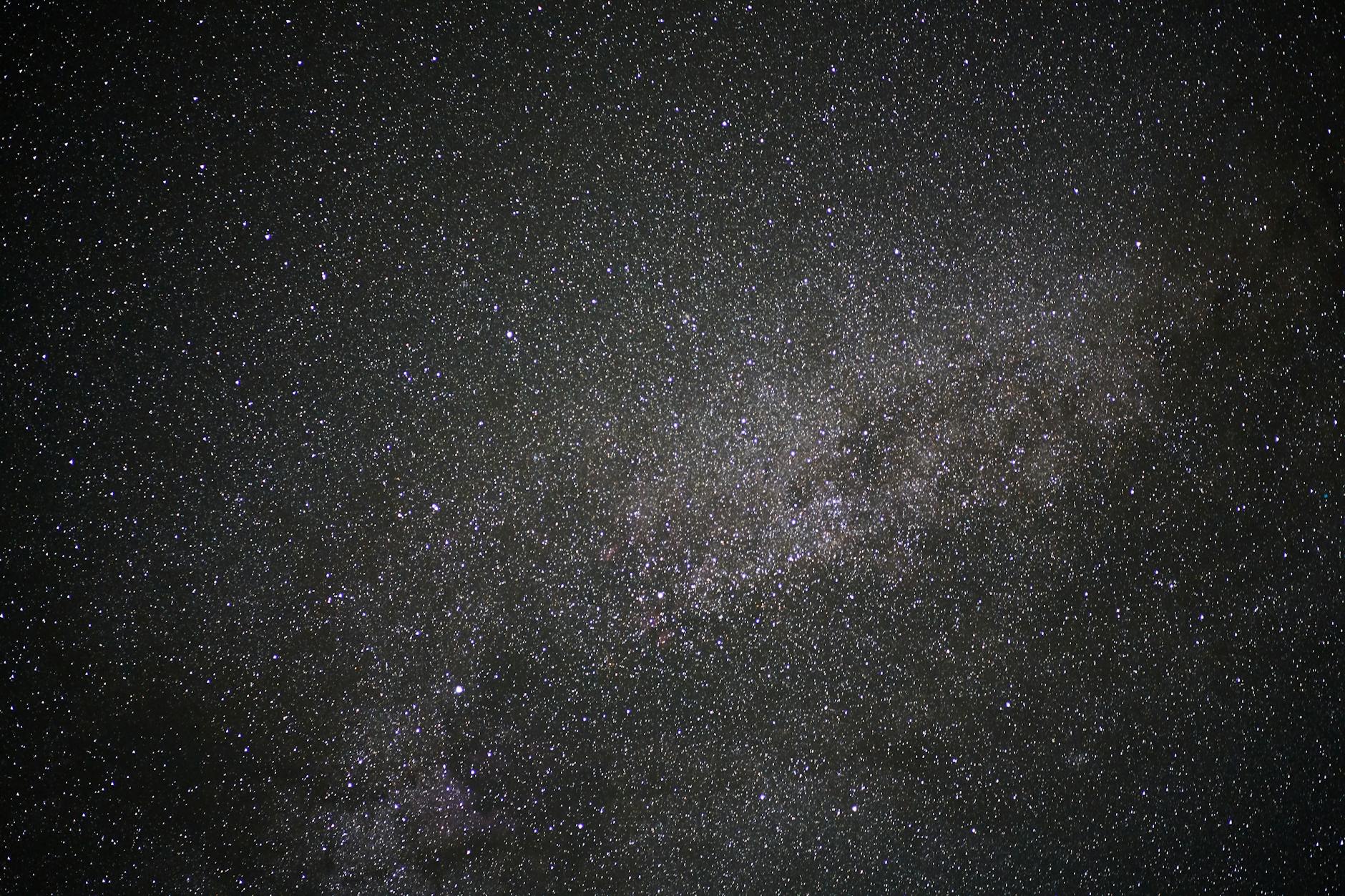 Night sky filled with stars over silhouetted desert rock formations