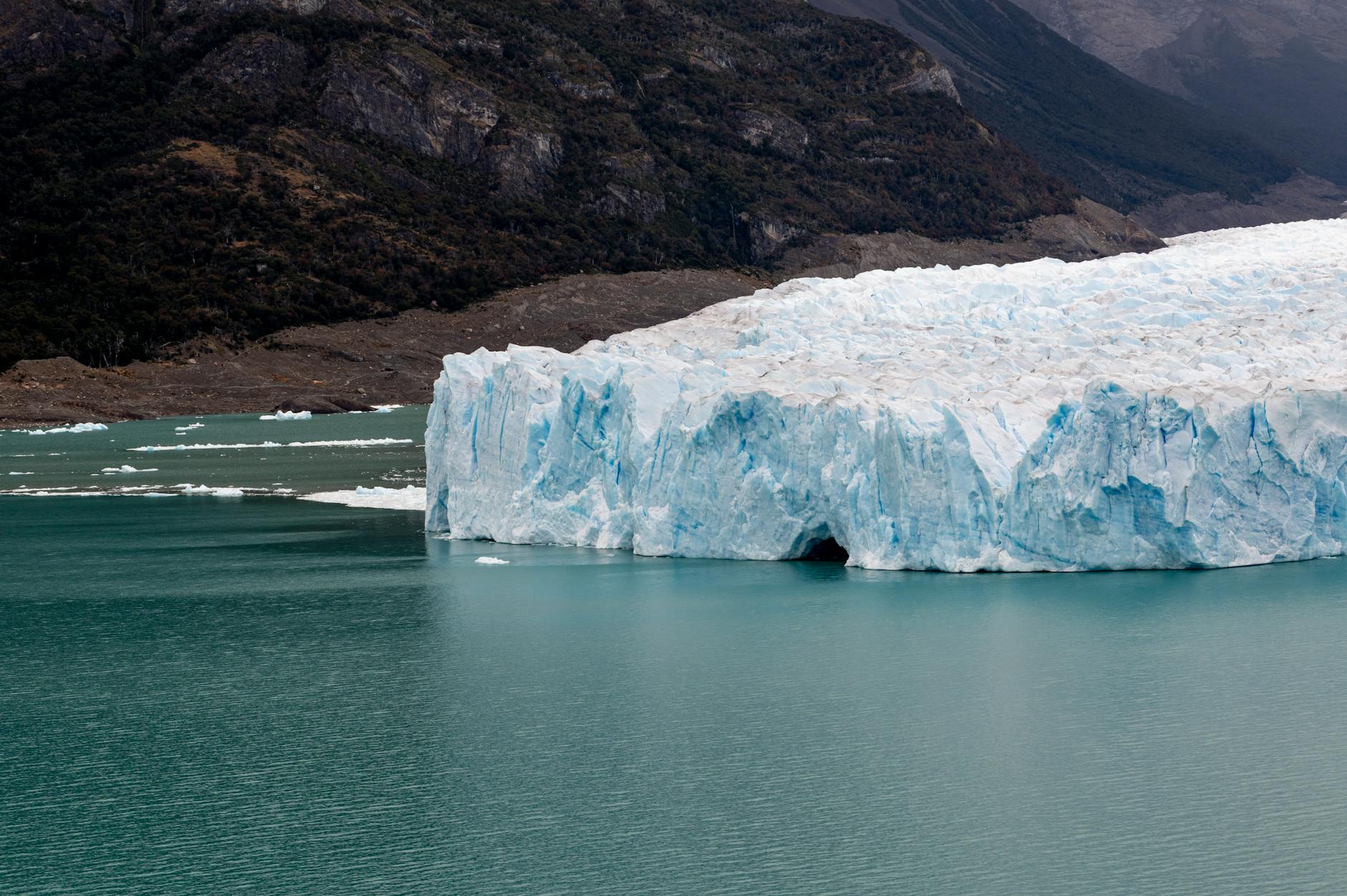 Wide view of a glacial landscape in Patagonia with ice fields and rocky peaks under a dramatic sky