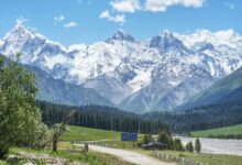 Wide view of snow-capped Tian Shan mountain peaks under a clear blue sky