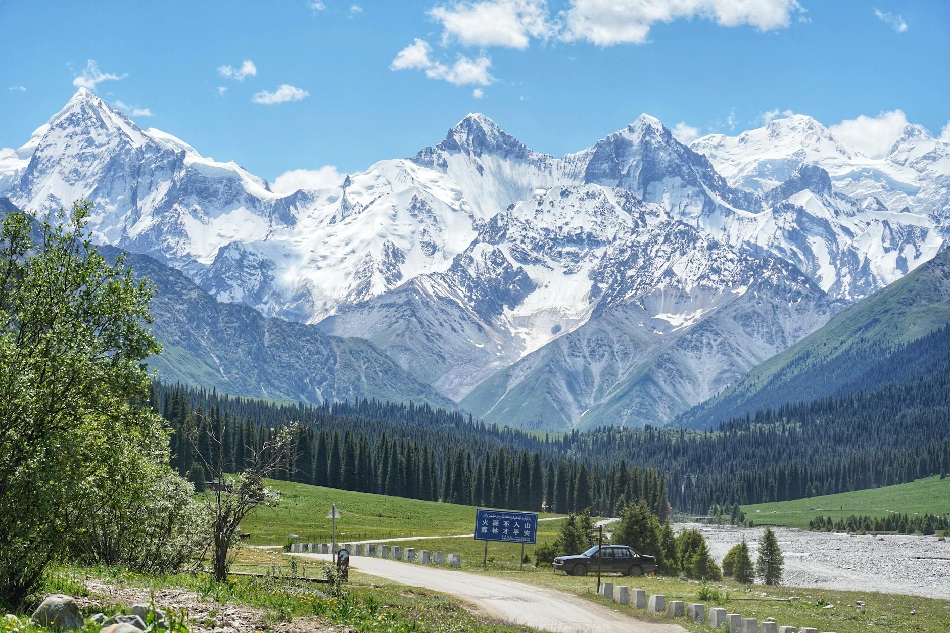 Wide view of snow-capped Tian Shan mountain peaks under a clear blue sky