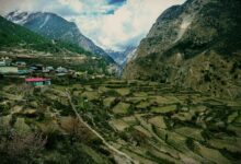 Remote Himalayan village with whitewashed buildings set against dramatic rocky cliffs in Upper Mustang, Nepal