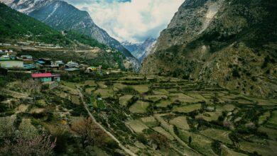Remote Himalayan village with whitewashed buildings set against dramatic rocky cliffs in Upper Mustang, Nepal