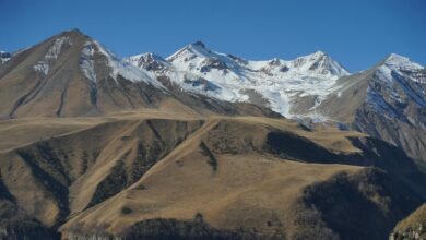 Snow-capped Caucasus mountain peaks rising above a green highland valley in Georgia