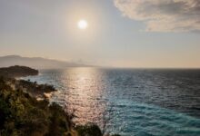 Clear blue Ionian waters along the Albanian Riviera coastline with rocky cliffs