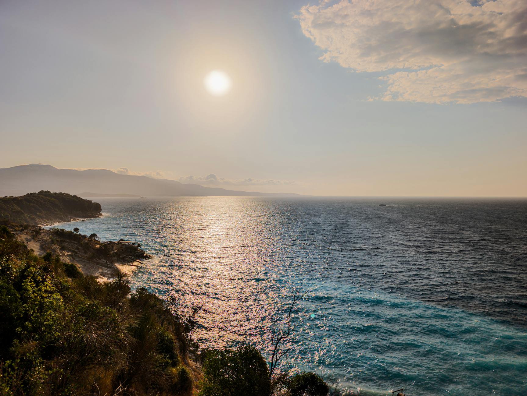 Clear blue Ionian waters along the Albanian Riviera coastline with rocky cliffs