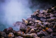 Steam rising from natural hot springs with mineral deposits
