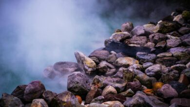 Steam rising from natural hot springs with mineral deposits