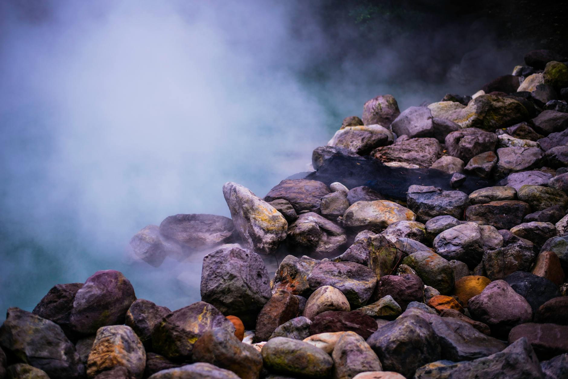 Steam rising from natural hot springs with mineral deposits