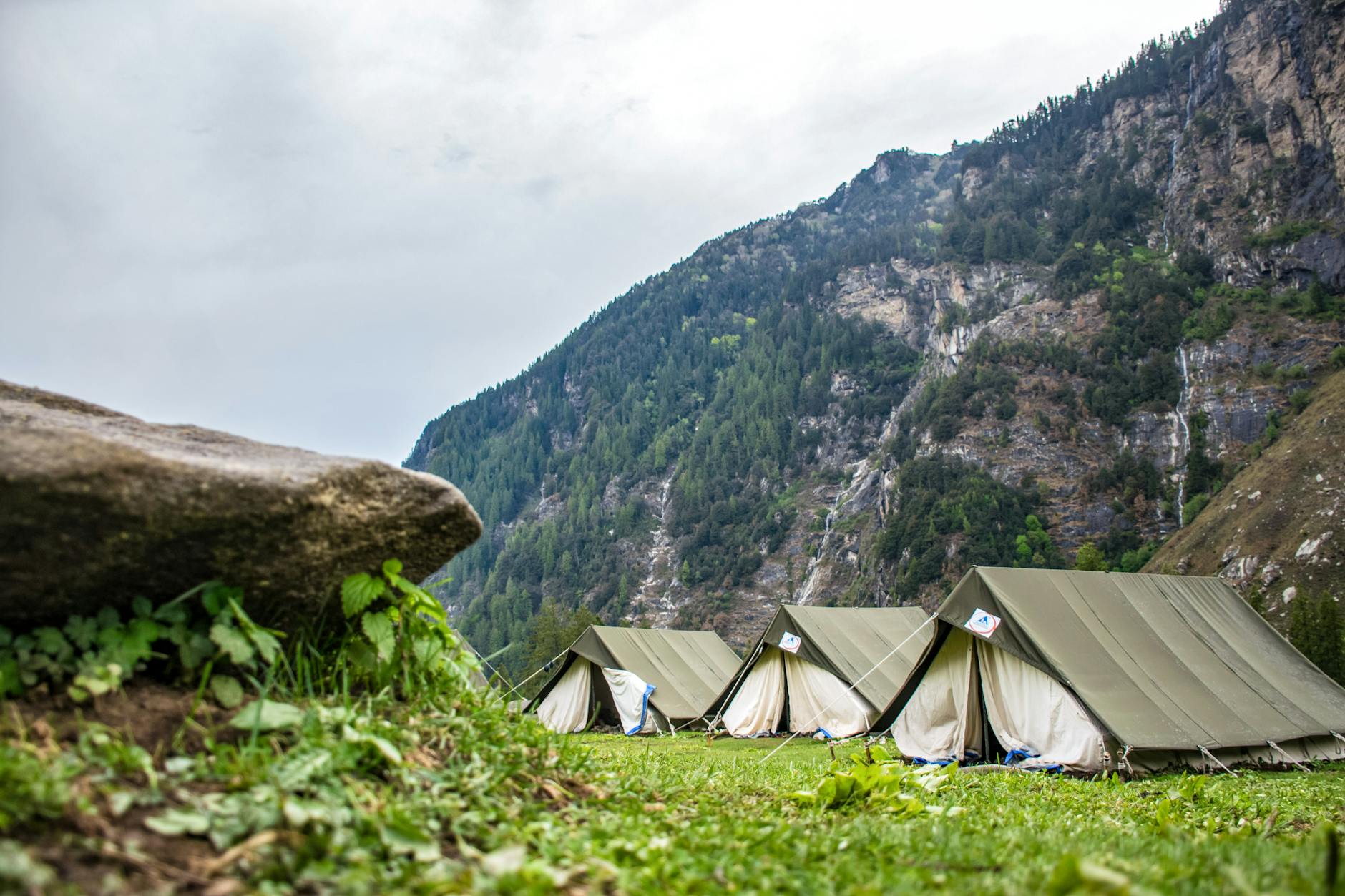 Small remote basecamp shelter on a rocky mountain terrain with distant peaks in the background
