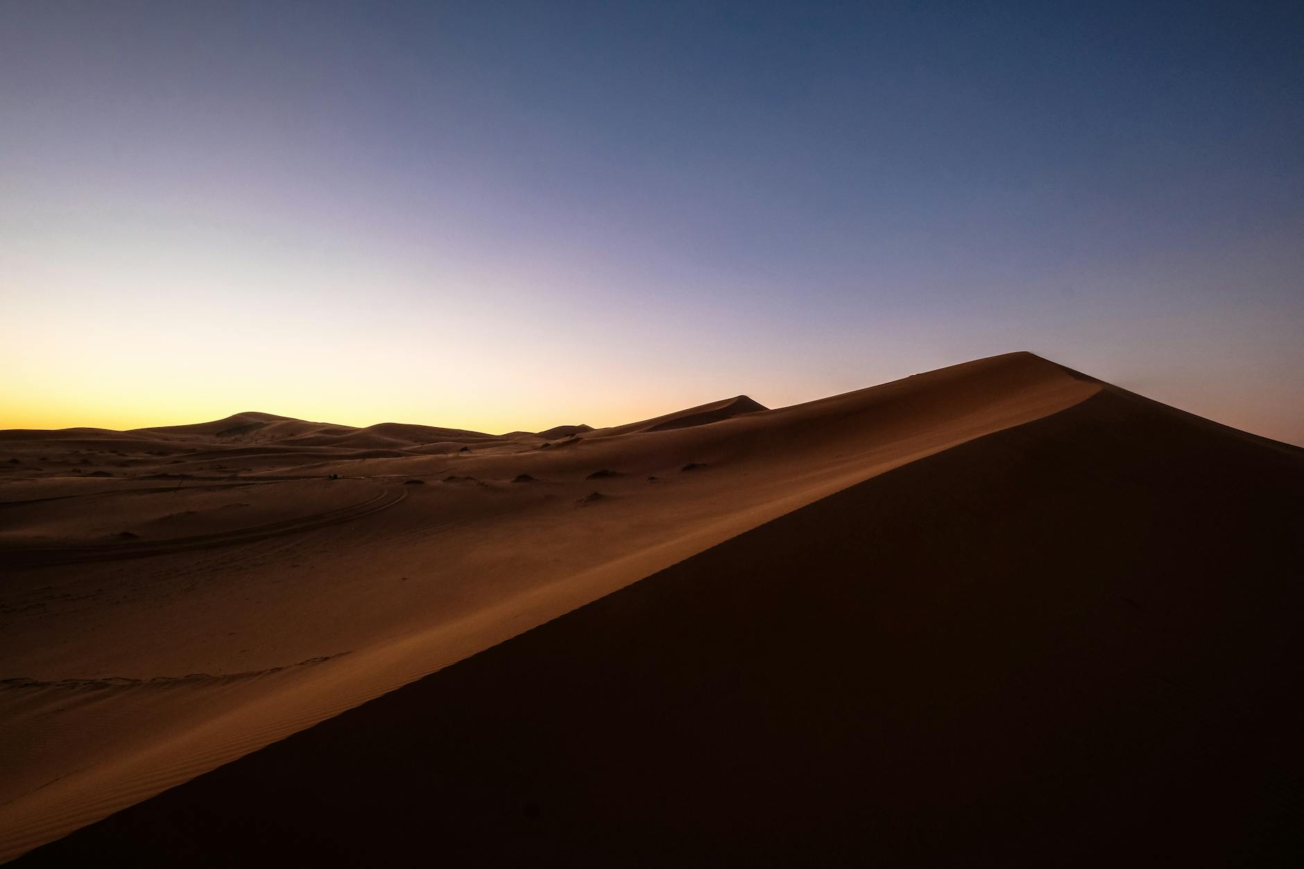 Sand dunes rising against a clear blue sky in the Moroccan pre-Saharan desert