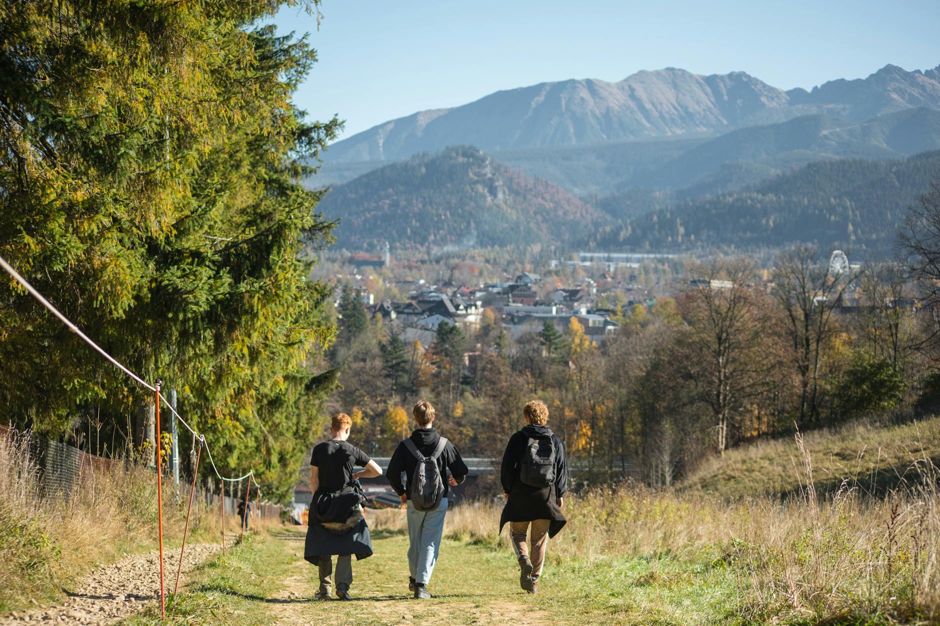 Hiker walking through a rural village trail surrounded by green farmland