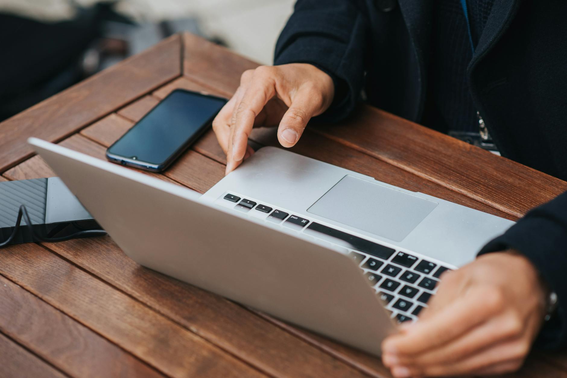 Person working on laptop in modern workspace setup with natural lighting