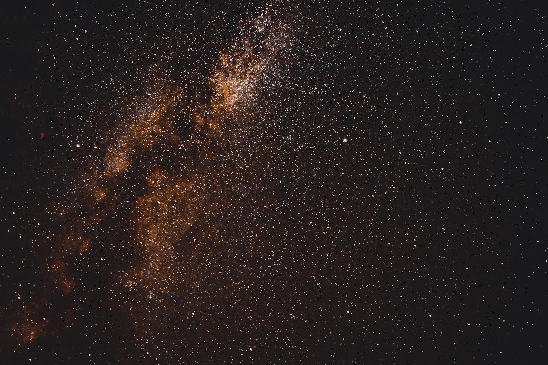 Clear night sky filled with stars and Milky Way galaxy visible above desert landscape