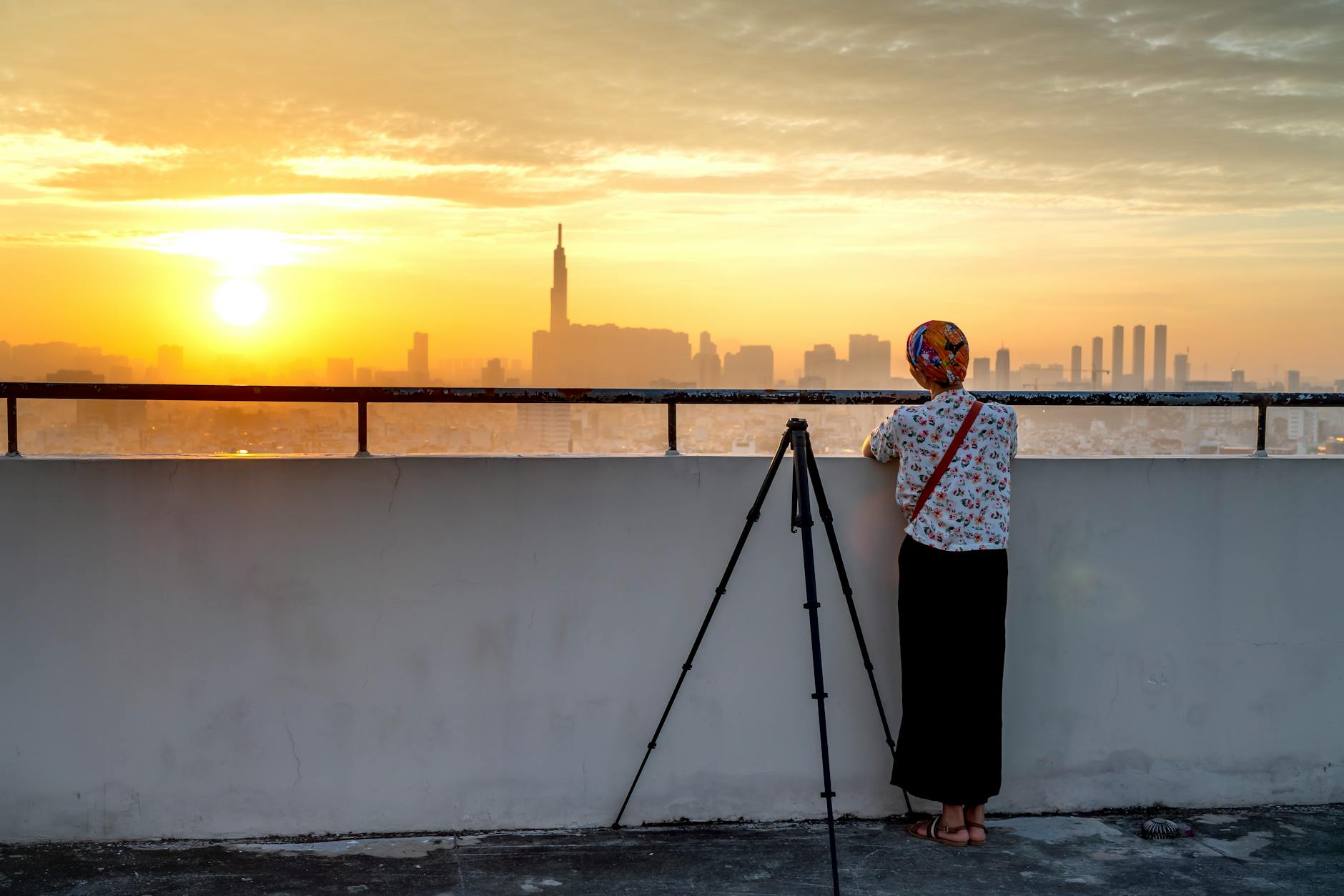 Photographer with tripod and camera set up at sunrise on a reflective flat surface
