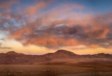Vast Atacama Desert landscape with volcanic peaks and salt flats under a clear blue sky