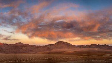 Vast Atacama Desert landscape with volcanic peaks and salt flats under a clear blue sky