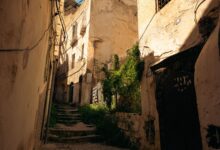 Narrow coral-stone alleyway in Zanzibar Stone Town with carved wooden doors and traditional architecture