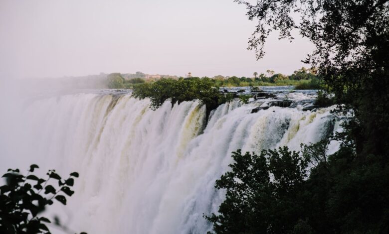 Wide view of the Zambezi River with green floodplains and distant escarpment under open sky
