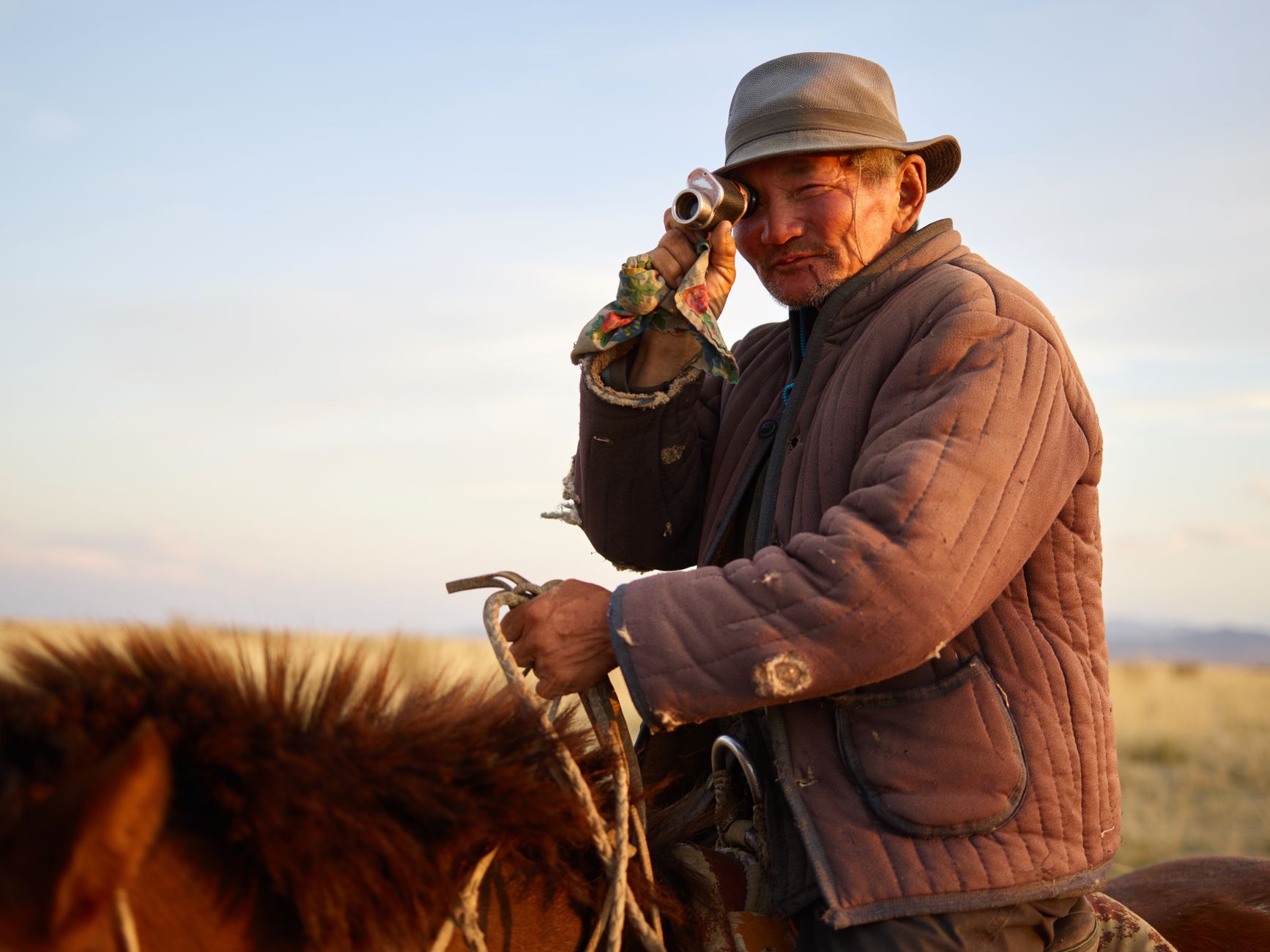 Wide open Mongolian steppe landscape with rolling grasslands under a vast blue sky