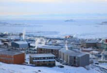 Colorful buildings of Longyearbyen settlement surrounded by snow-covered Arctic mountains