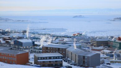Colorful buildings of Longyearbyen settlement surrounded by snow-covered Arctic mountains