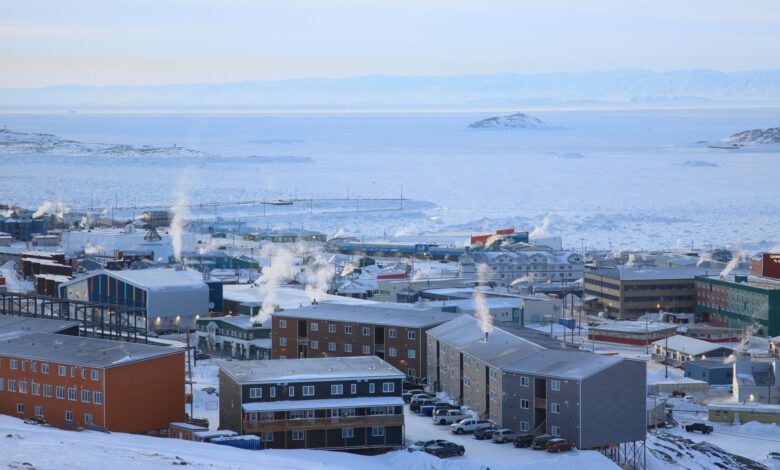 Colorful buildings of Longyearbyen settlement surrounded by snow-covered Arctic mountains