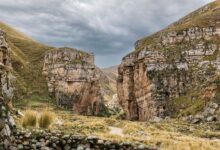 Deep Andean canyon with terraced hillsides and a river running through the valley floor