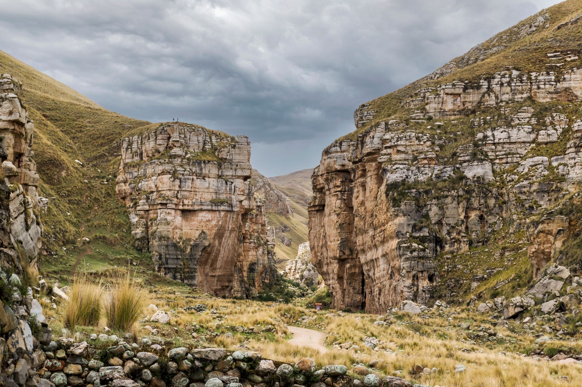 Deep Andean canyon with terraced hillsides and a river running through the valley floor