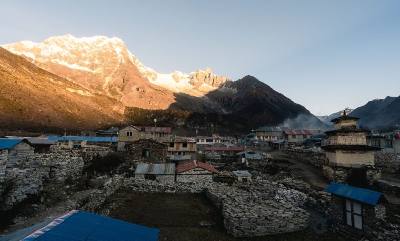 Wide view of a dry high-altitude landscape in Nepal with rocky cliffs and distant Himalayan peaks