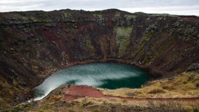 Turquoise volcanic crater lake surrounded by steep Andean caldera walls at high altitude