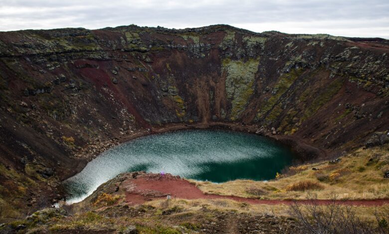 Turquoise volcanic crater lake surrounded by steep Andean caldera walls at high altitude