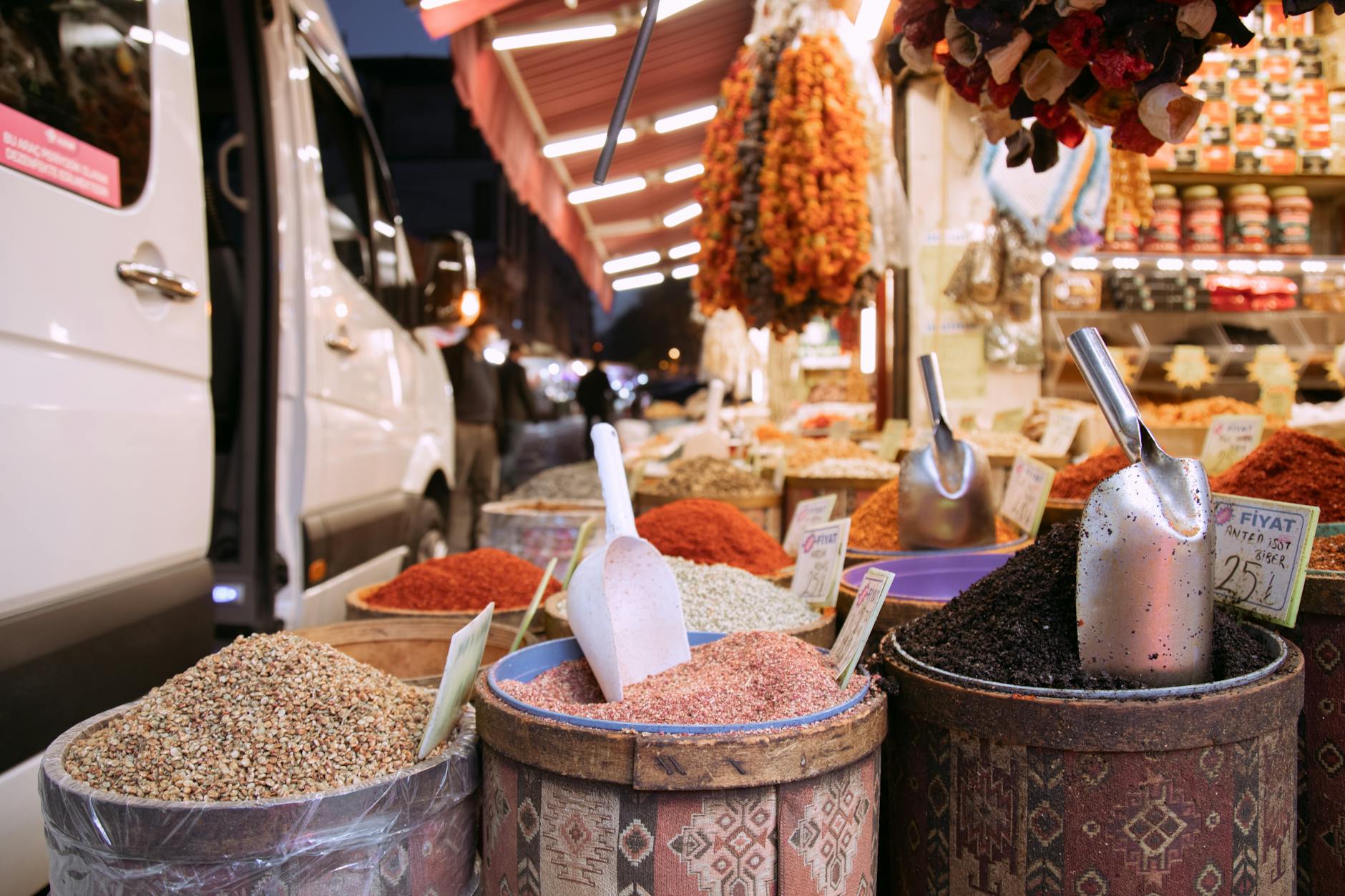 Colorful spice and produce stalls at an East African market with vendors and fresh goods on display
