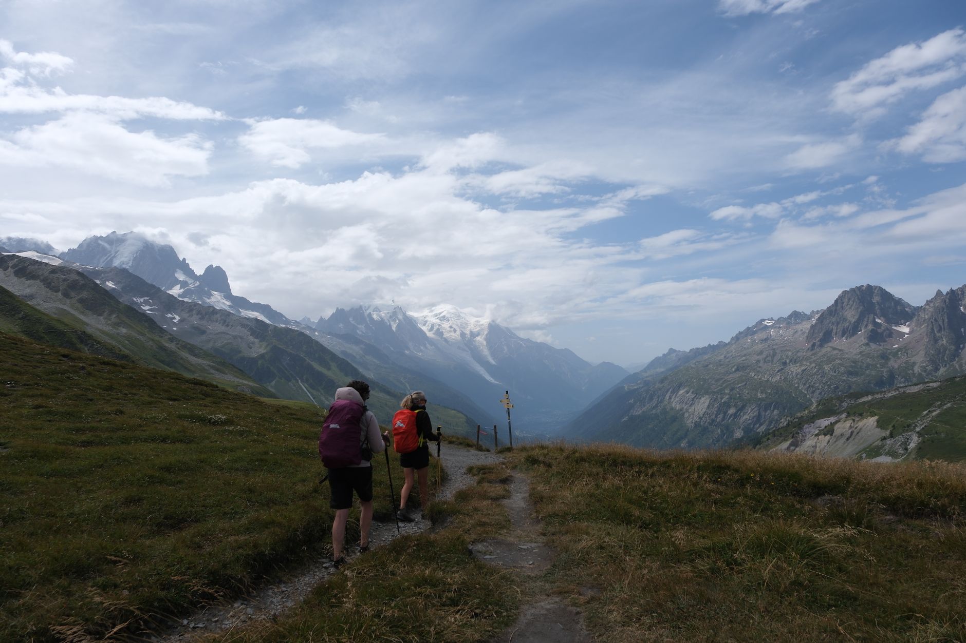 Trekker walking along a high-altitude trail through rocky mountain terrain