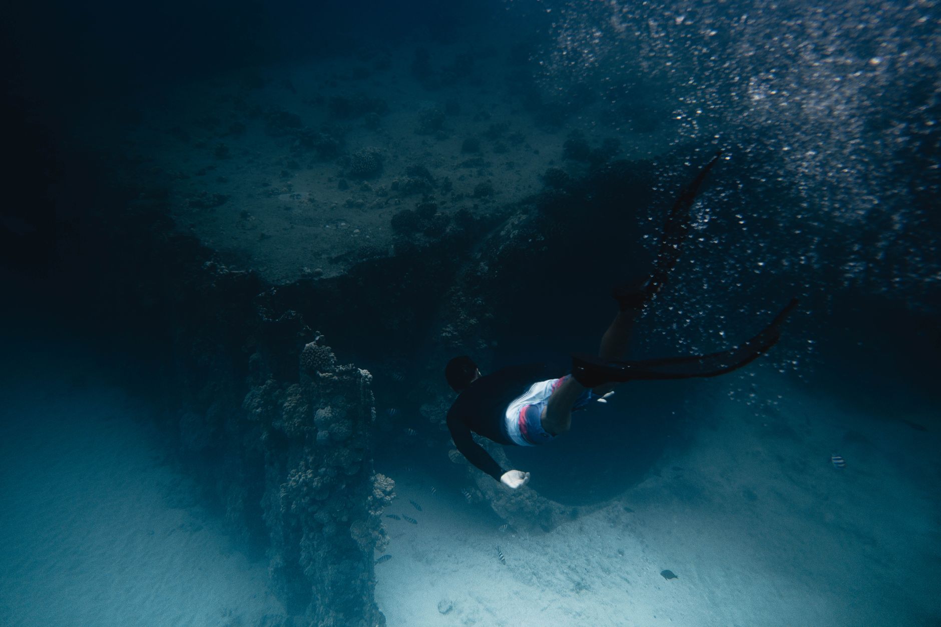 Scuba diver exploring a vibrant coral reef formation underwater