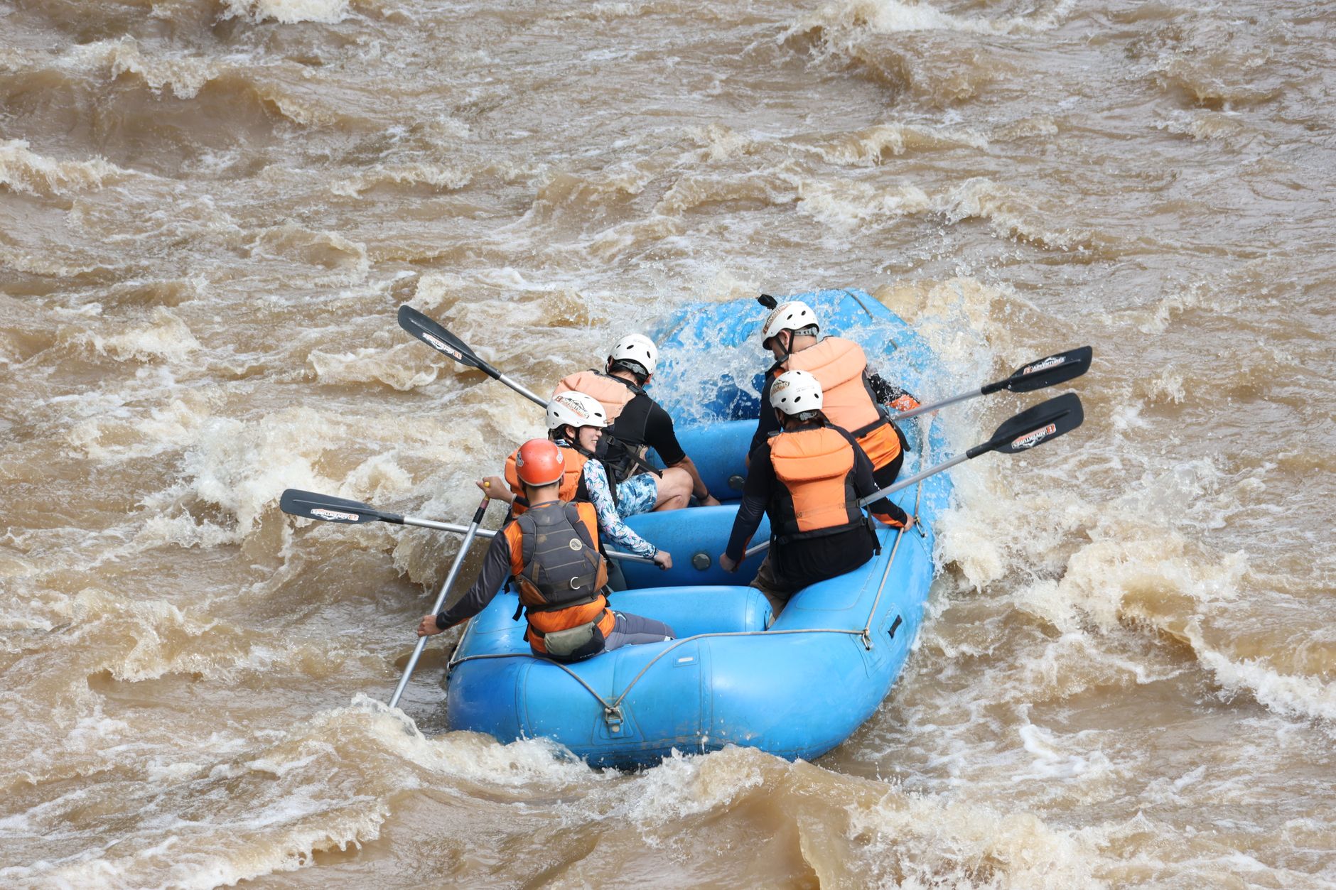 Group of rafters navigating a river canyon with steep rocky walls