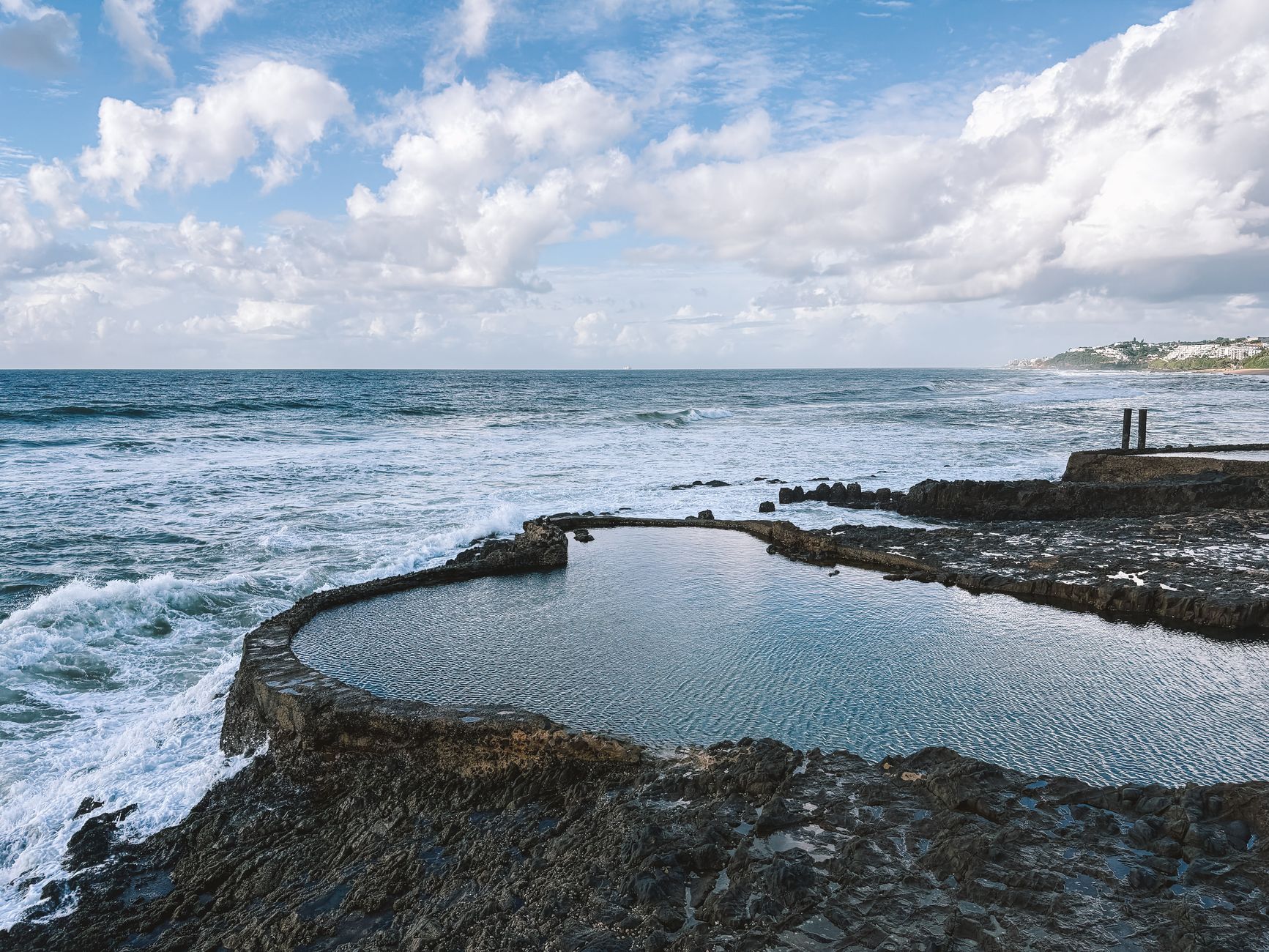 Clear freshwater natural pool surrounded by rocky canyon walls and tropical vegetation