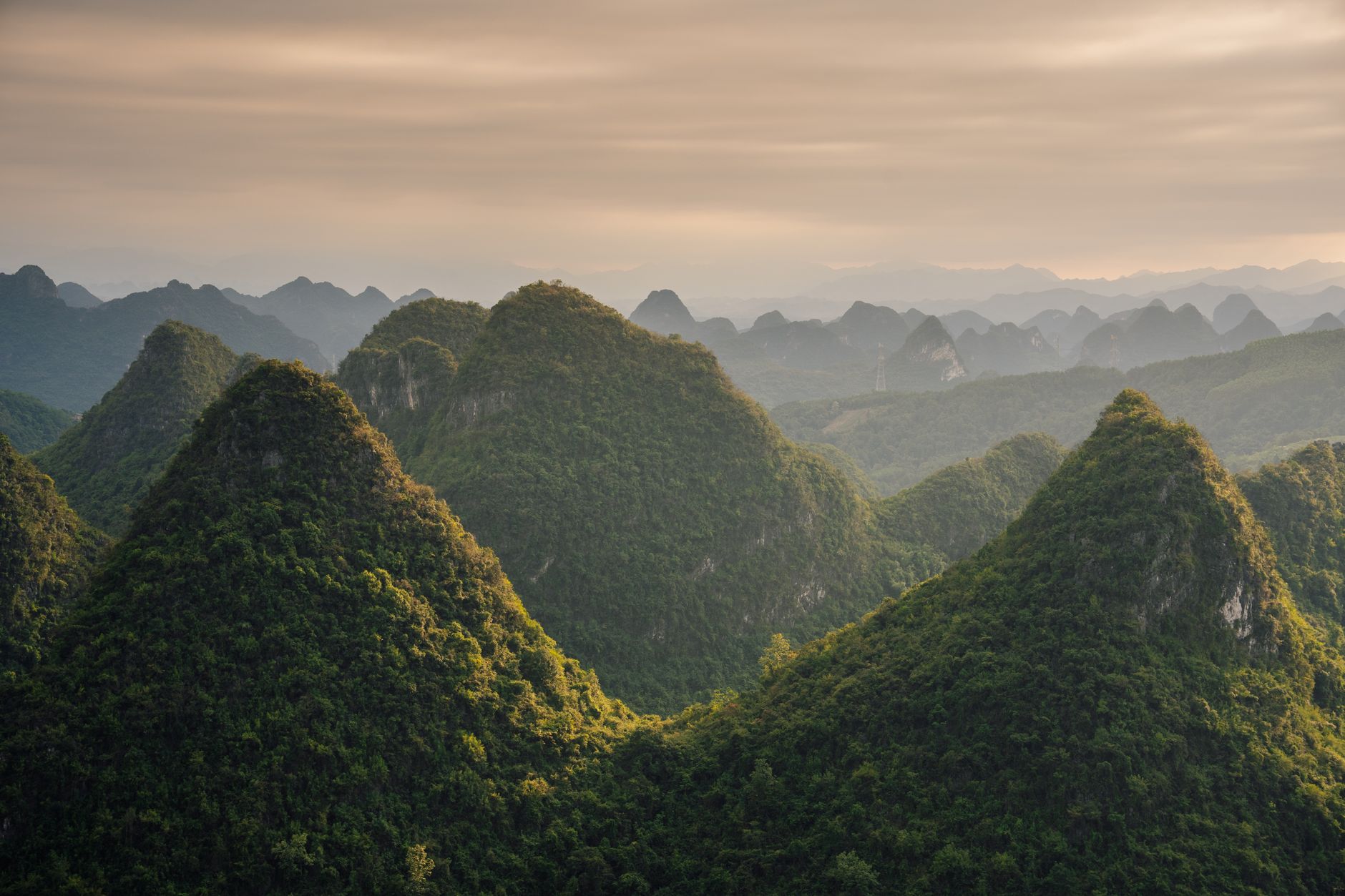 Dramatic karst limestone peaks rising above a river valley in Southeast Asia