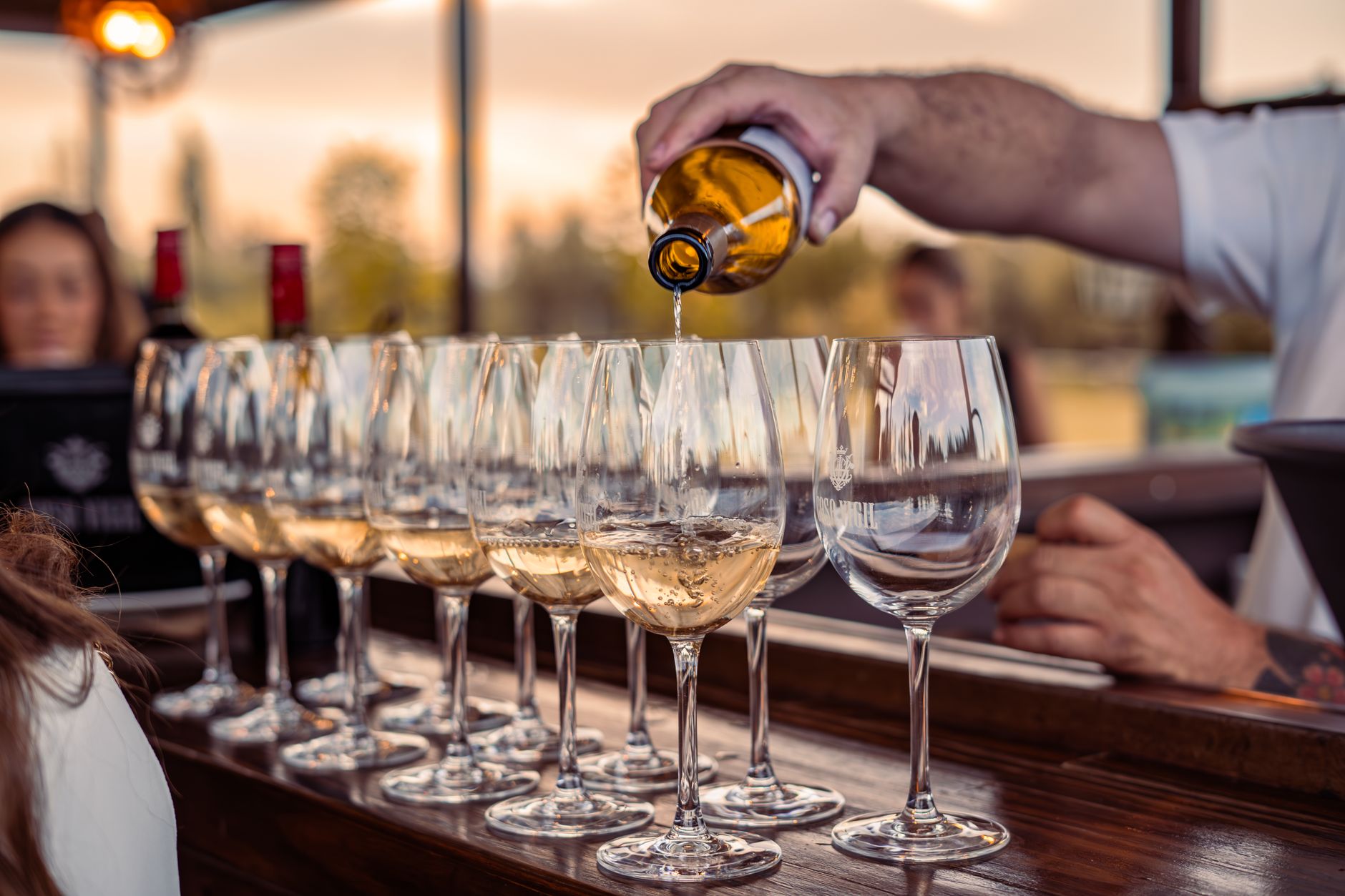 Two glasses of red wine on a rustic wooden table outdoors at a vineyard