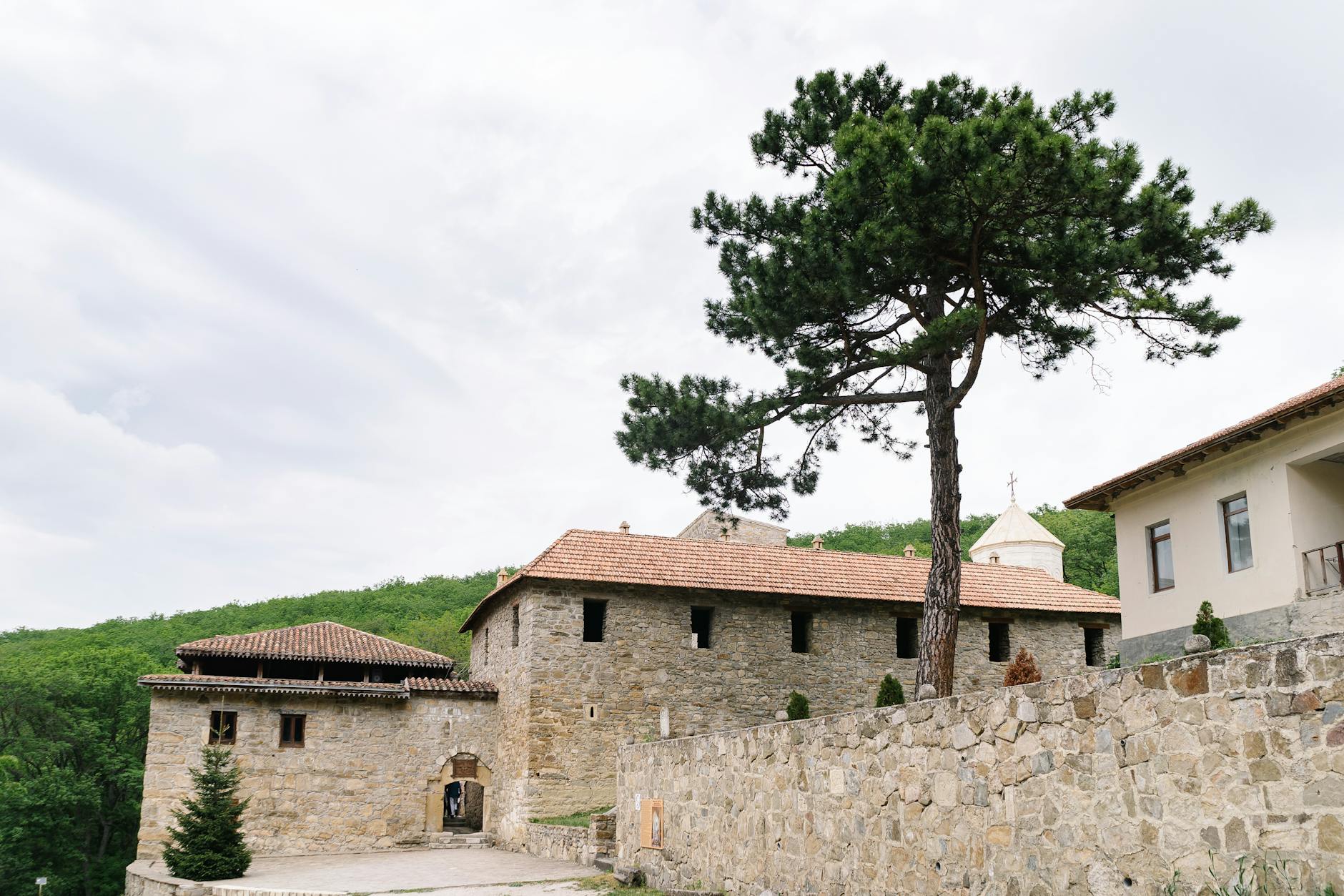Medieval stone monastery surrounded by old-growth forest in the Caucasus